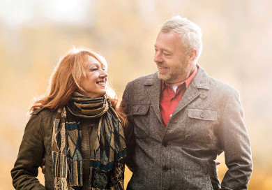 An older Caucasian couple walking together in the fall